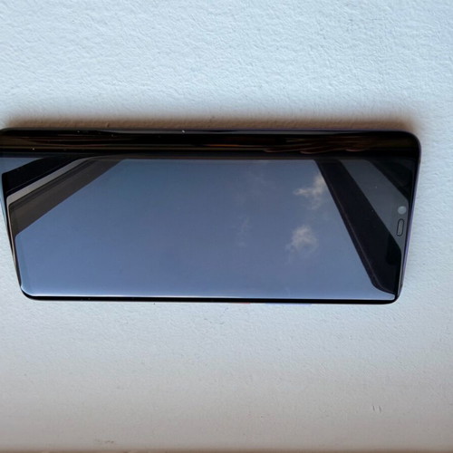 Huawei Mate 20 Pro smartphone with charging cable, cracked screen