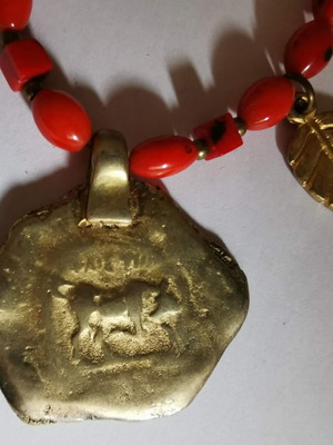 Ethnic necklace like new with gold decorative pendant and red beads